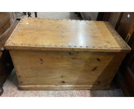 An 89cm Victorian pine lift-top trunk with studded top and flanking iron drop handles