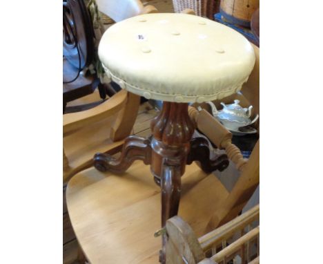 A Victorian rosewood revolving piano stool, set on ornate pillar and tripod base