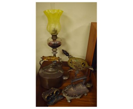 Group of metal wares comprising: paraffin lamp, trivet with turned wooden handle, oval kettle, flatiron and stand, together w