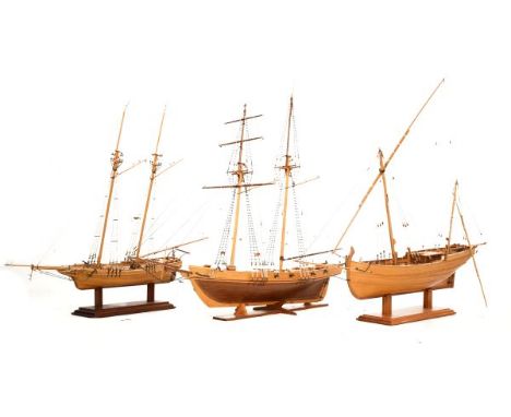 Three wooden scale models of tall-masted sailing ships, the largest with detailed cannons, fittings etc, together with stands