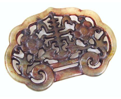 A 19thC Chinese jade buckle, of shell outline heavily carved to the centre with flowerheads and branches, 6cm wide.