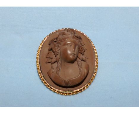 A lava stone carved cameo, female portrait in mount, stamped '9CT'