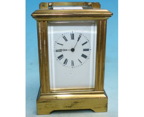 A 19th century miniature brass carriage clock with replacement swing handle, square reeded side pillars and bracket feet, hav