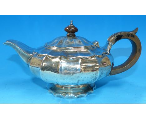 An early 19th century teapot of squat circular ribbed form, on raised foot, with boxwood handle, London 1822, 9 oz.