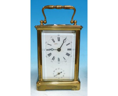 A 19th century brass carriage clock with swan neck swing handle and ogee side columns, on cut away plinth base, with white en