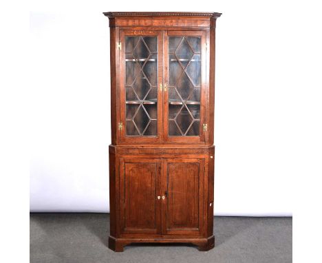 George III oak and mahogany freestanding corner cupboard, beaded and cavetto cornice, above an inlaid frieze, the upper secti