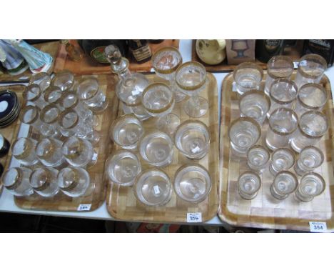 Three trays of matching drinking vessels and trifle bowls, all with etched decoration and gilded collars, to include; tumbler