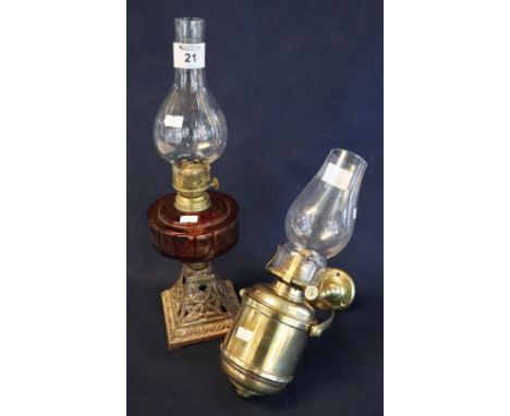 Early 20th Century brass single burner oil lamp with glass reservoir on cast metal base having clear chimney, together with a