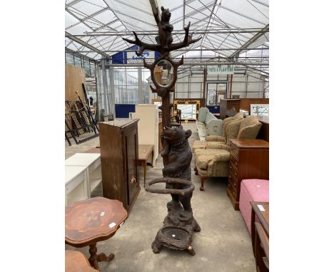 A BLACK FOREST STYLE BEAR HAT AND STICK STAND WITH OVAL MIRROR AND SMALL BEAR AT THE TOP WITH DRIP PAN TO THE BASE, 86" HIGH 