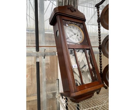AN OAK CASED CHIMING WALL CLOCK 