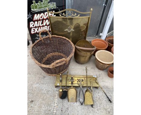 AN ASSORTMENT OF FIRE SIDE ITEMS TO INCLUDE A BRASS FIRE SCREEN, A LARGE WICKER LOG BASKET, BRASS COMPANION ITEMS ETC 