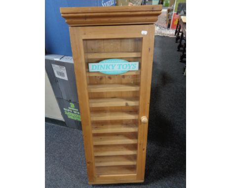 A pine collector's cabinet bearing Dinky advertising 