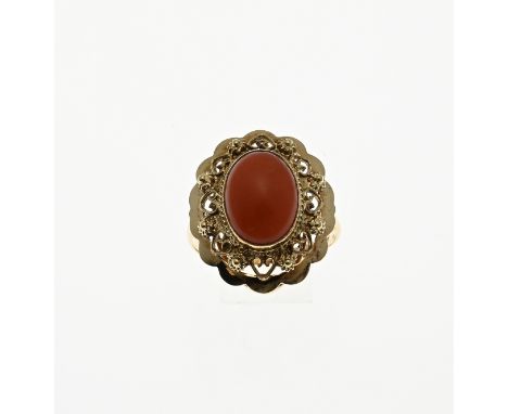 Yellow gold ring, 585/000, with a blood coral. Ring with an oval openwork head with buttons. Set with an oval cabouchon blood