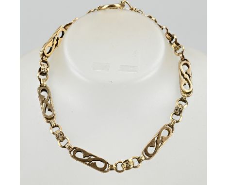 Yellow gold chatelaine, 585/000, with elongated links, openwork with S-decor. Between the links is a link with floral element