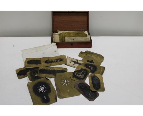 A wooden mahogany box with contents of vintage metal stencils 