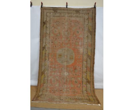 Khotan carpet, east Turkestan, 19th century, 10ft. 3in. x 5ft. 8in. 3.12m. x 1.73m. Overall wear, heavy in places; overall fa