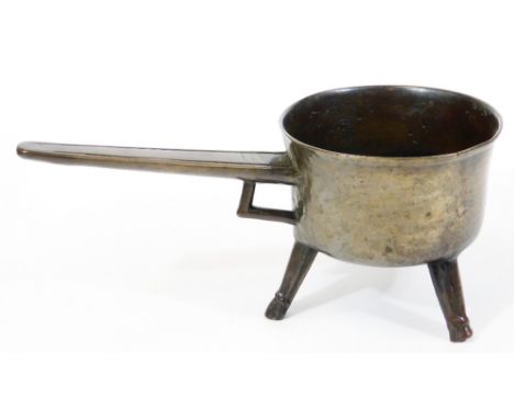 A 17th/18thC bronze posnet or skillet, with taper handles and tripod base, 14cm high, 15cm diameter, 34cm long.