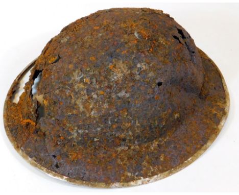 An early 20thC tin war helmet, of domed form, 14cm high. (AF)