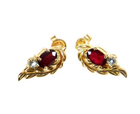 A pair of earrings,  each of shaped form, claw set with two stones, certificated as ruby and swish blue topaz on 9k setting, 