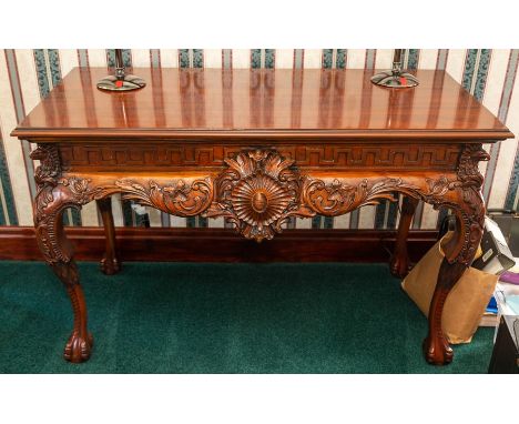 A mahogany console table of Adam design, carved frieze and serpentine apron, cabriole legs, claw and ball feet, width 136cmNo