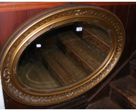 Decorative oval wall mirror in gilt frame