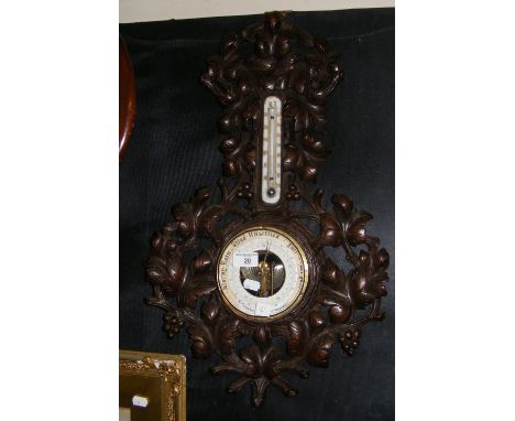 A Black Forest carved wood cased barometer/thermometer by Campbell, Hamburg