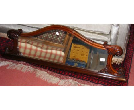 A hall mirror in shaped mahogany surround