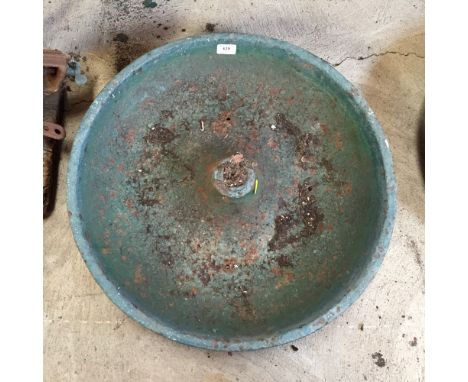 A circular cast iron pig trough