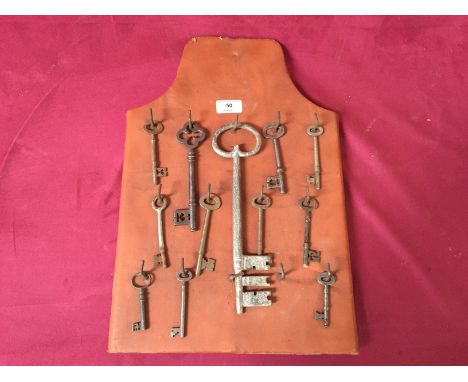 A collection of Vintage iron keys hung to a keyboard