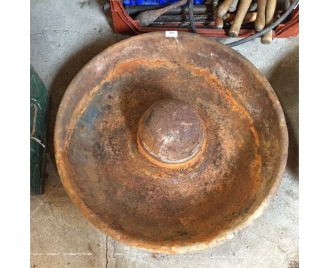 A circular cast iron pig trough