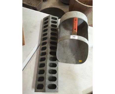 An Eltex galvanised chicken feeding trough; and a galvanised food scoop