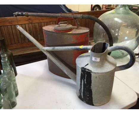 A Vintage red painted metal fire fighting back pack; and a galvanised watering can with long spout