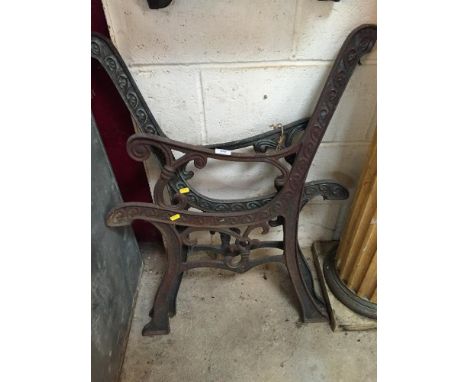 A pair of ornate cast iron bench ends