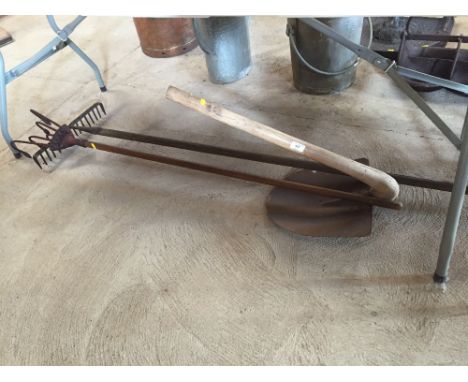 A Vintage iron shovel with angular handle; a wooden rake; and a wooden handled cultivator