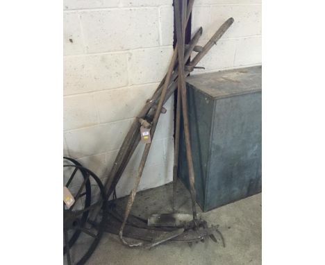 A collection of Vintage tools including scythes, rake etc.