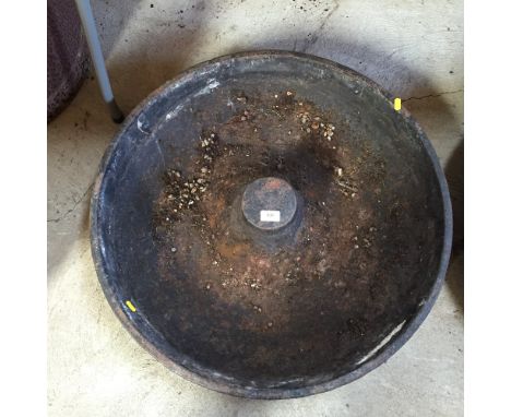 A circular cast iron pig trough