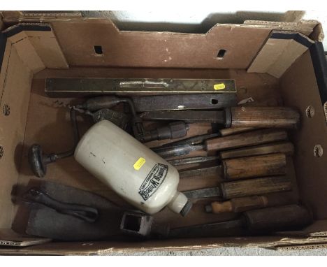 A box of various old chisels; spirit level; a brace; Timothy Whites hot water bottle; vintage can opener etc.