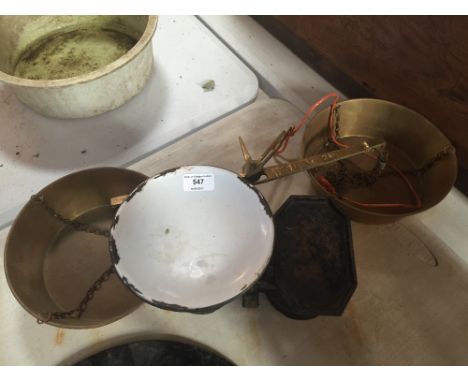 A pair of brass hanging scales and a set of iron and enamel kitchen scales