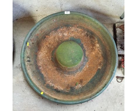 A small circular cast iron pig trough
