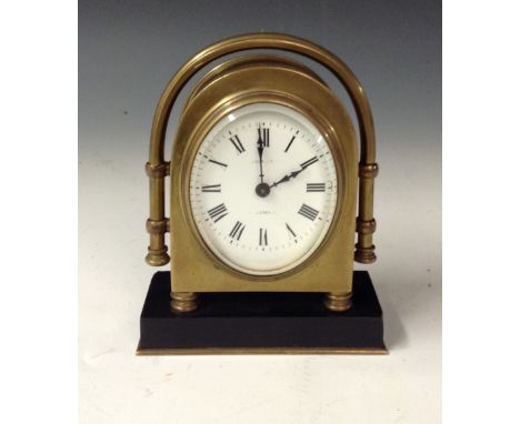 An early 20th century brass desk timepiece, 6cm oval enamel dial inscribed Morrison, Barnstaple, the arched case with retract