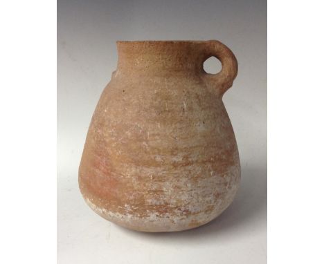 Antiquities - a wheel-thrown twin-handled terracotta storage jar, 26cm high; with an associated newspaper clipping referring 