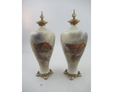 A pair of Royal Worcester covered vases, decorated with Highland cattle by John Stinton, raised on stylized dolphin feet, sha
