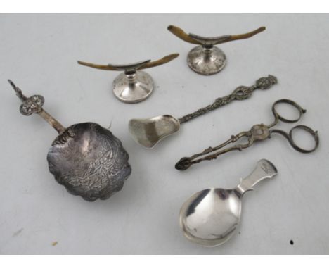 A pair of silver scissor action sugar nips, together with a pair of knife rests, a silver caddy spoon and other items