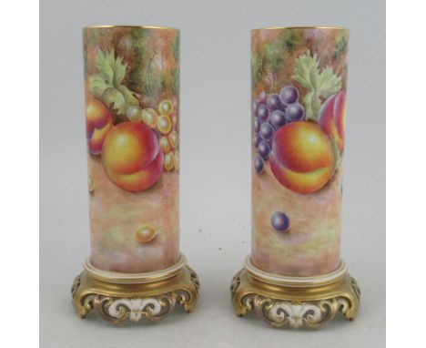 A pair of Royal Worcester cylindrical vases, decorated all round with fruit to a mossy background by Leaman, with pierced gil