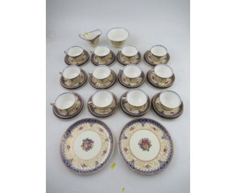 A Royal Worcester tea service, decorated with a central panel of flowers by Sedgley and Mole to a blue and gilt boarder and c