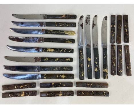 Twelve Japanese bronze and gilt handled table knives, together with twelve matching handles, depicting a variety of subjects 