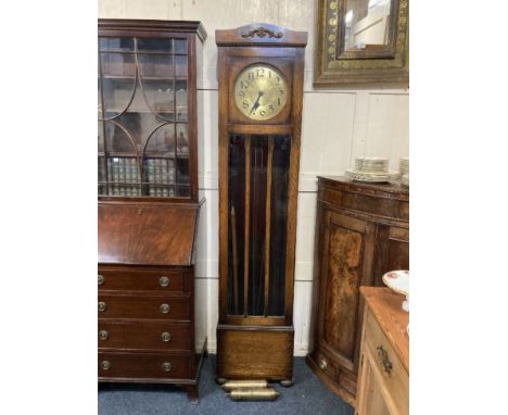 A 20th century oak longcase clock, the circular 10 1/2inch brass dial with Arabic numerals, the movement striking Westminster
