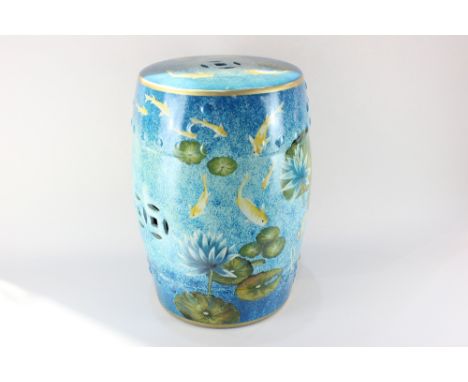 A glazed ceramic garden seat, barrel shaped, decorated with fish swimming amongst water lilies, 47cm