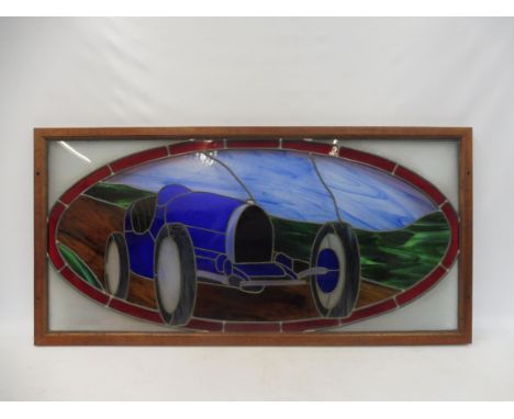 J. RAINEY - a stained glass panel showing a Bugatti Type 35, in a wooden frame, 47 1/2 x 23 1/2".