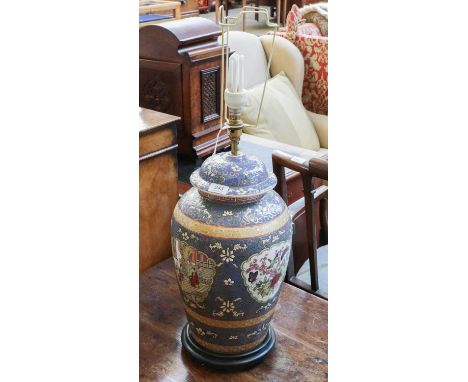 A large 20th century Chinese porcelain vase and cover, converted to electricity as a lamp base, raised on a carved wooden sta